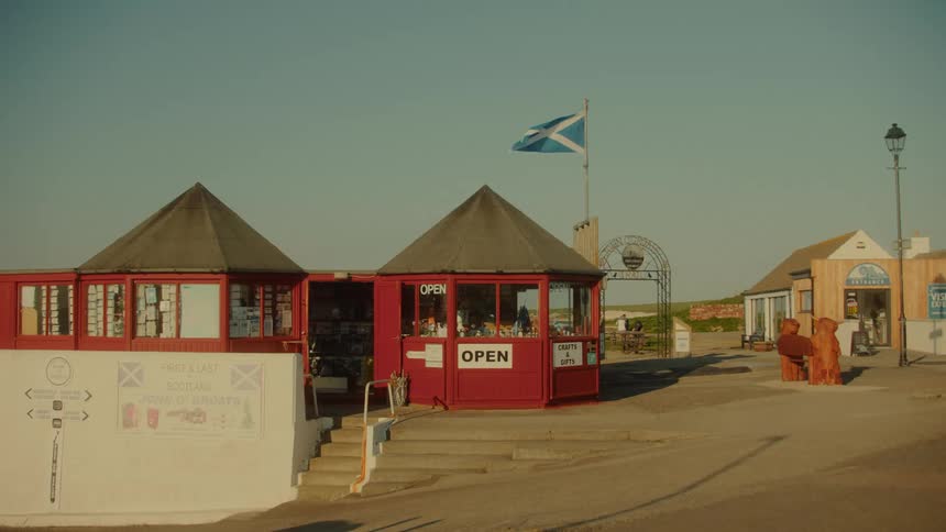 Tourist kiosks with the scottish flag raised in a coastal area of john ogroats