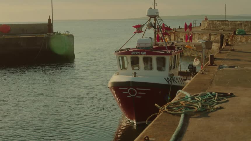 Fishing boat moored at a pier with maritime equipment around it