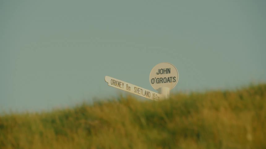 A view of a sign in a grassy field
