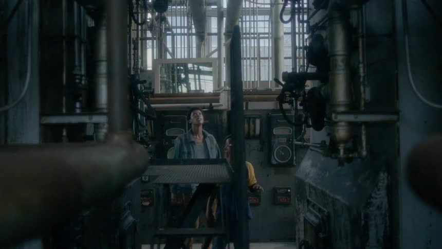 Two boys run around an industrial building