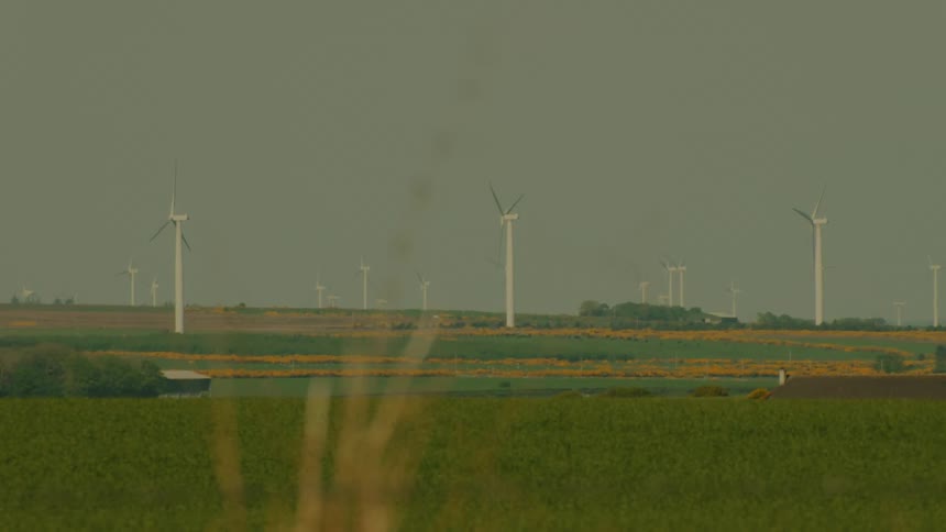 A view of some windmills in a field