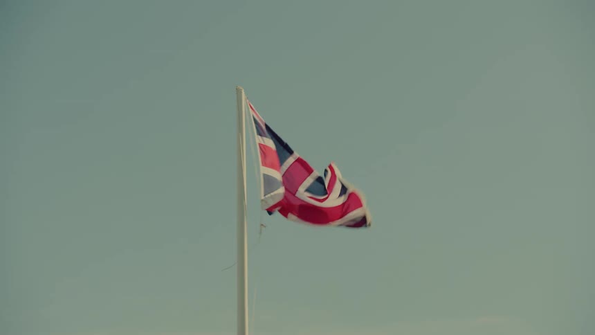 United kingdom flag flying on a pole against a clear sky