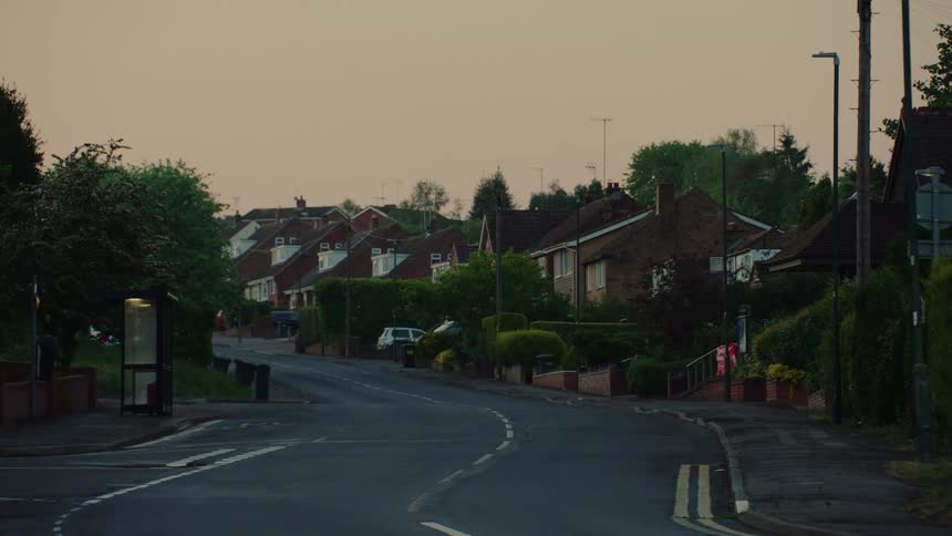 Traffic passes a neighborhood street with houses close together