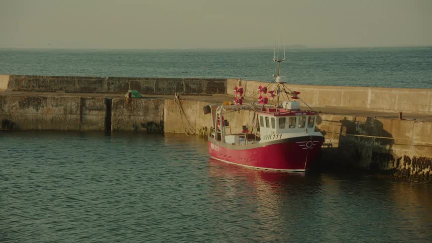 Boat docked in the harbor moves with the current of the water