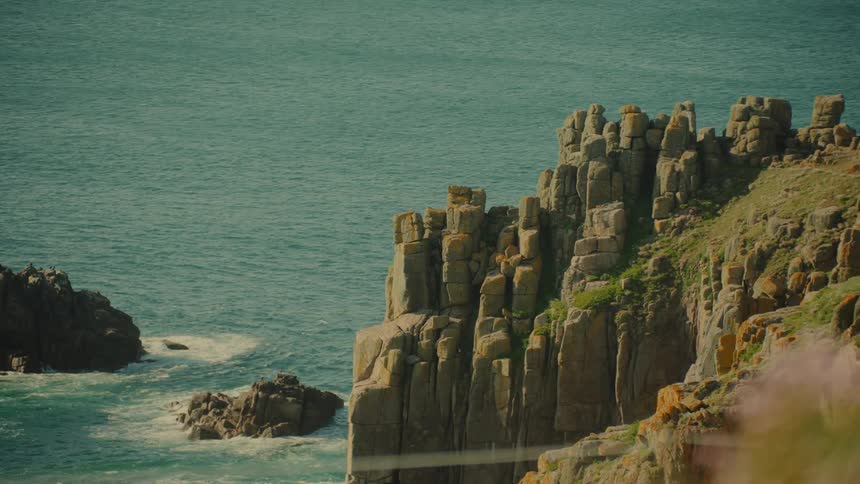 A coastal landscape on a sunny day with rocky cliffs