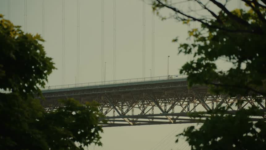 People ride bicycles across a bridge