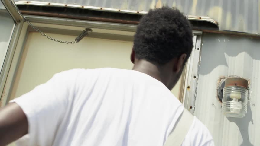 A man walks up steps to a door and enters the building