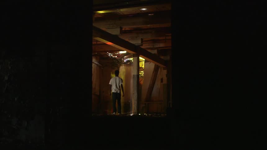 A young boy walks up to a spray painted door