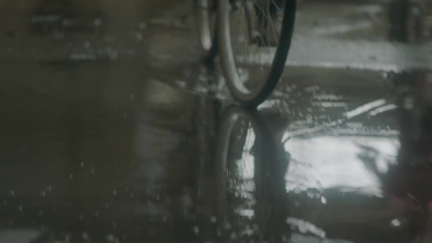 People riding bicycles on a wet paved surface