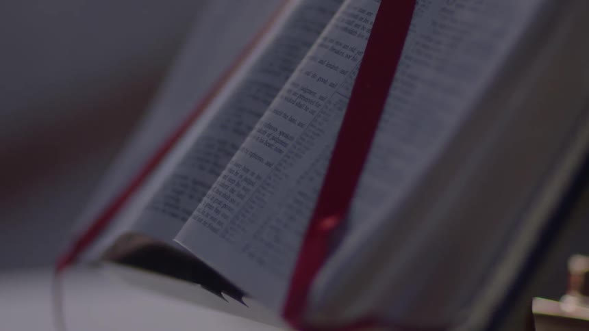 Red ribbon holds back the pages of a book