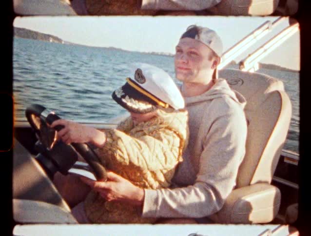 A father and daughter are driving a boat in a lake