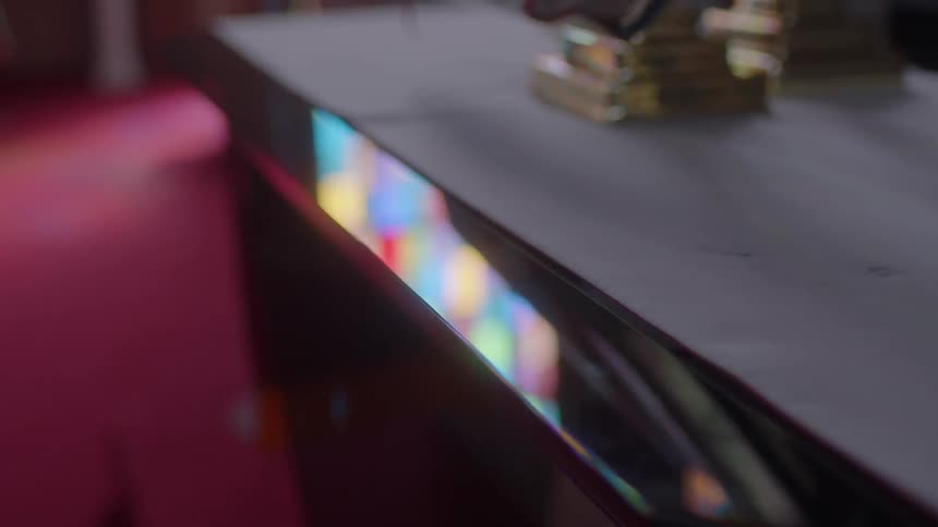 Stained glass reflects off a glossy finish desk