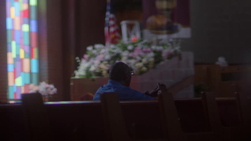 A man sits in the seats at a memorial service