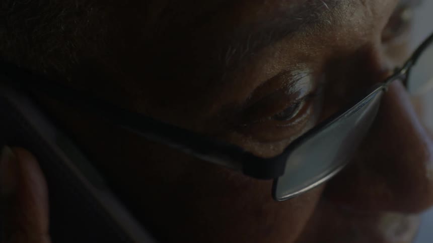An older man is listening to his cellphone