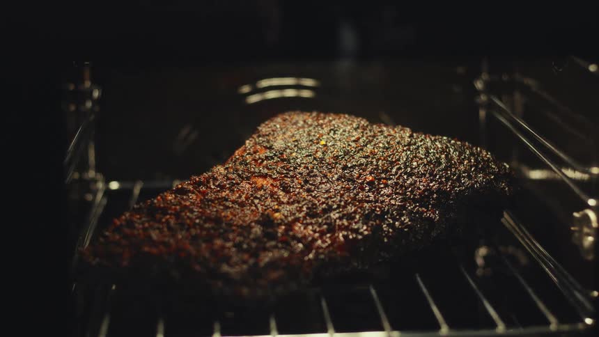 Large piece of meat cooks directly on a rack in an oven