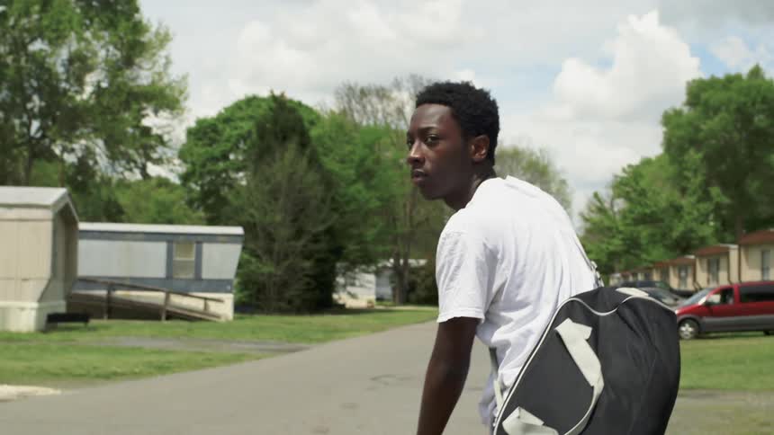 Man looks over his shoulder in a trailer park