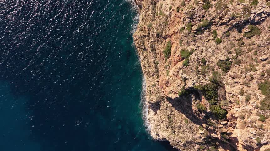 Small waves hit the rocky cliffs