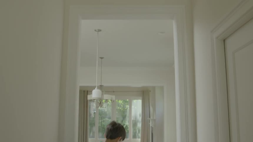 Two boys run through the house