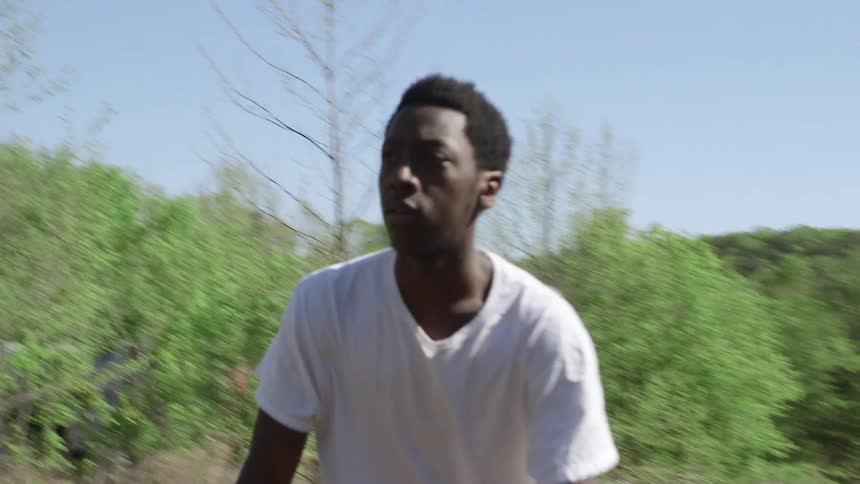 A man rides a bike through a scrubby area