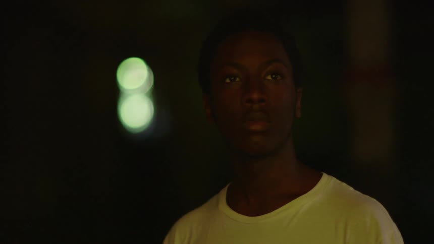 A man walks into a dark room looking around