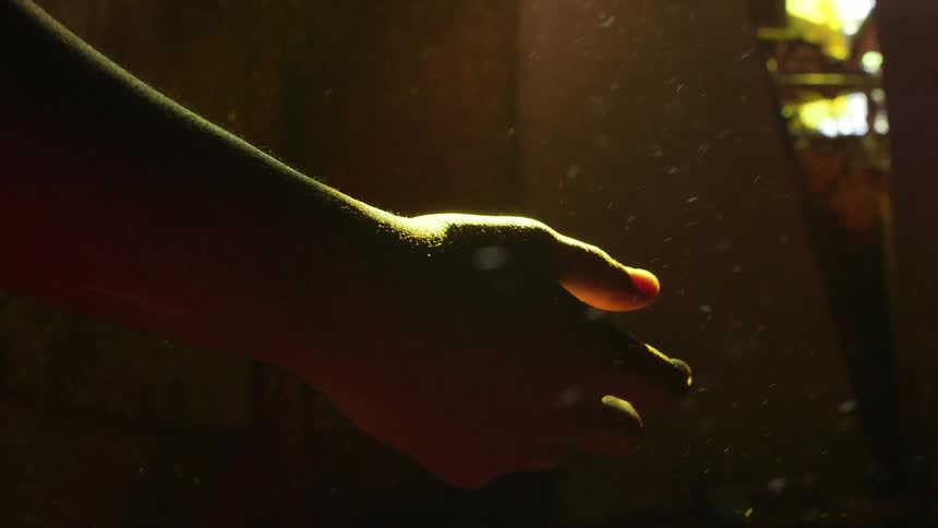 Dust particles flow around an outstretched hand