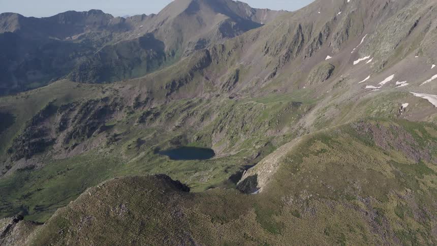 Aerial footage of a mountain range that surrounds a valley