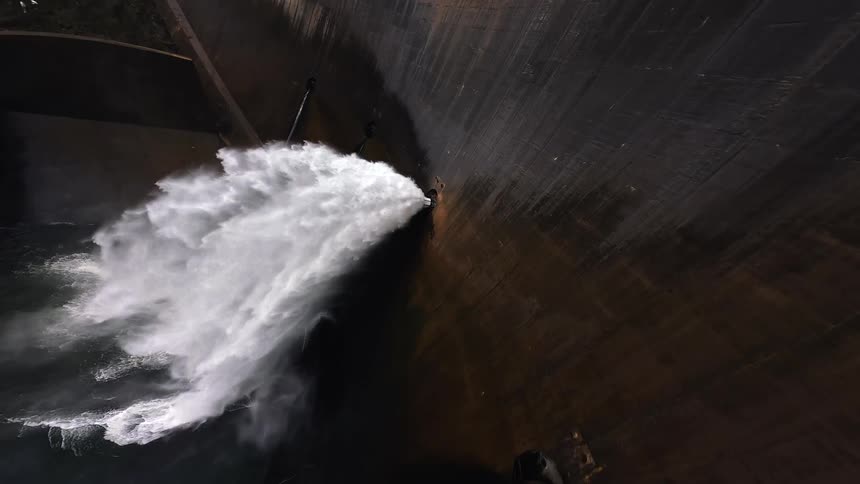 Water pours from holes in the dam