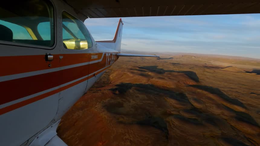 A view of a plane flying over a desert