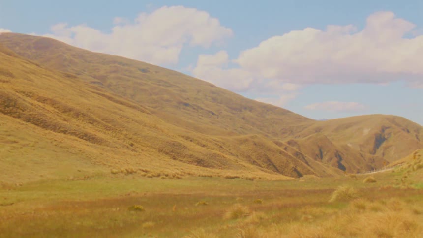 Golden hills under a blue sky with clouds