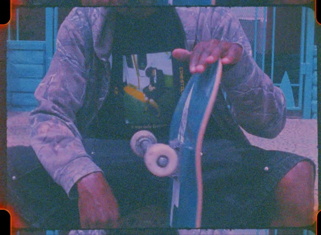 The man spins the skateboard on the stoop
