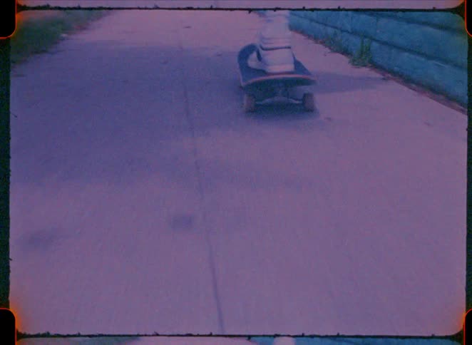 The person is riding their skateboard on the sidewalk