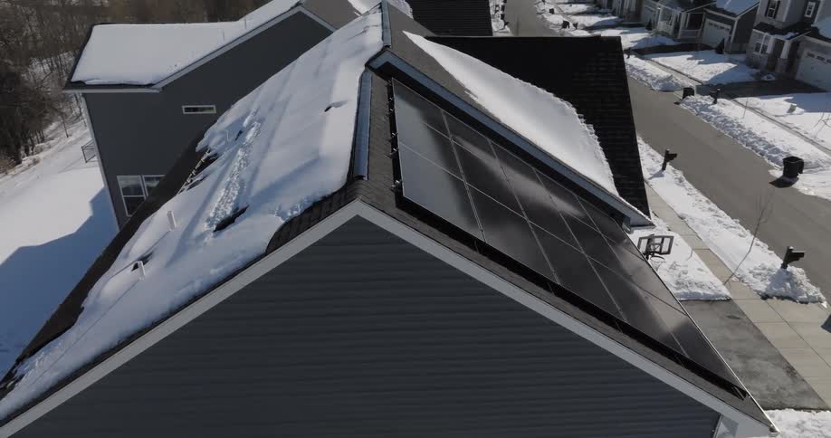 Solar panels installed on a snowcovered roof in a residential area