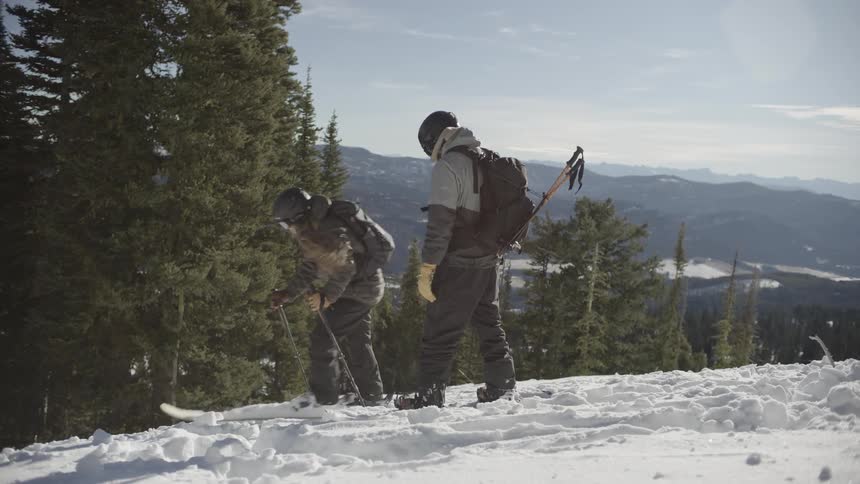 Skiers equipped on snowy slope