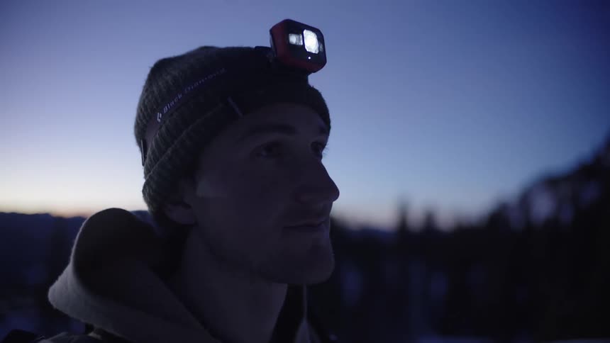 Man with a headlamp on a snowy mountain
