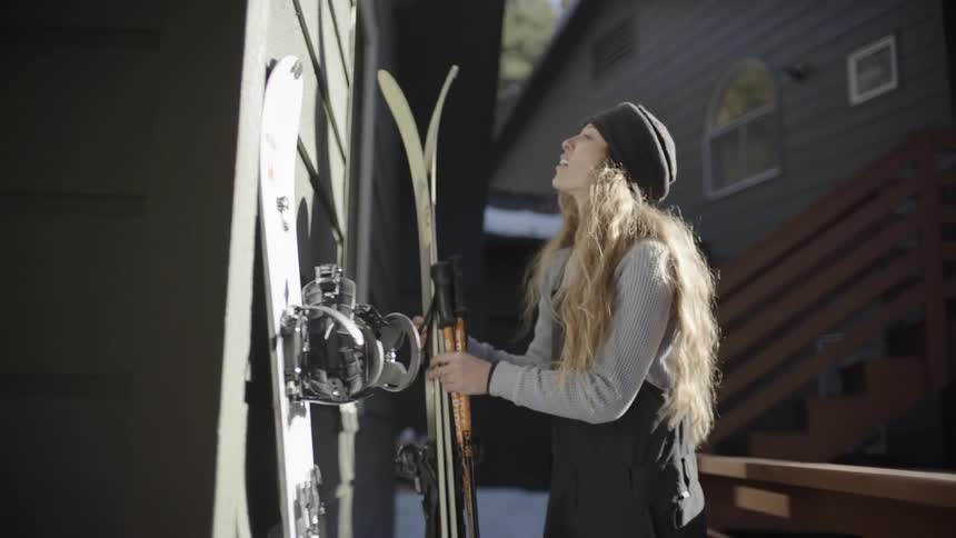 Skier arranges gear on outdoor rack