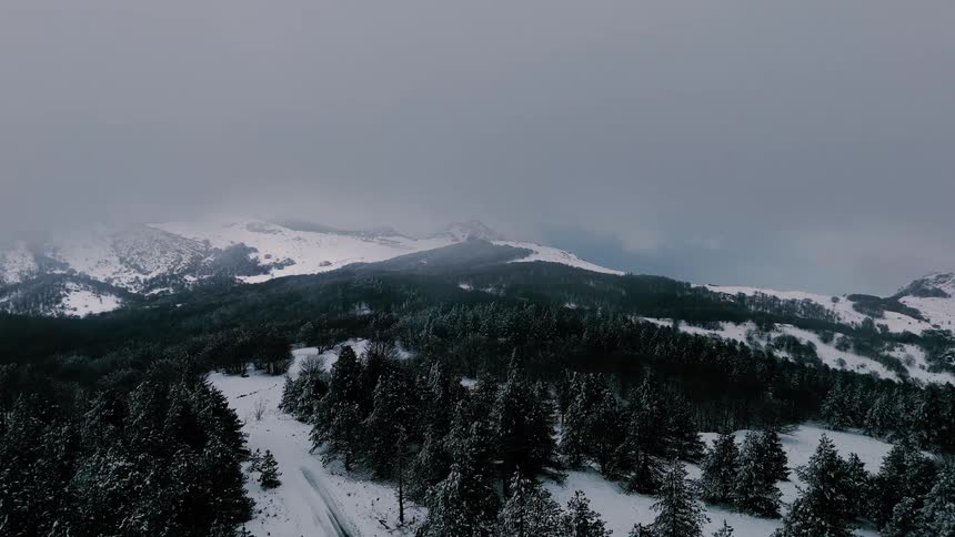 An aerial view of a mountain covered in snow
