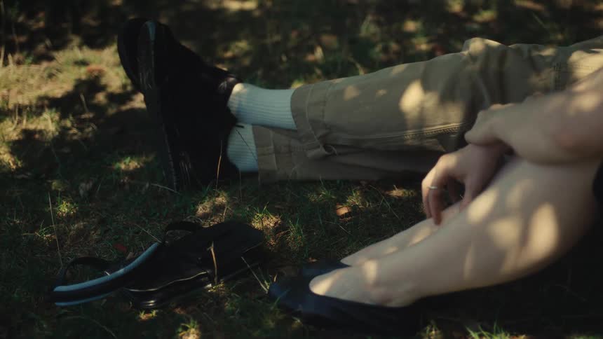 People sitting on grass in shaded area
