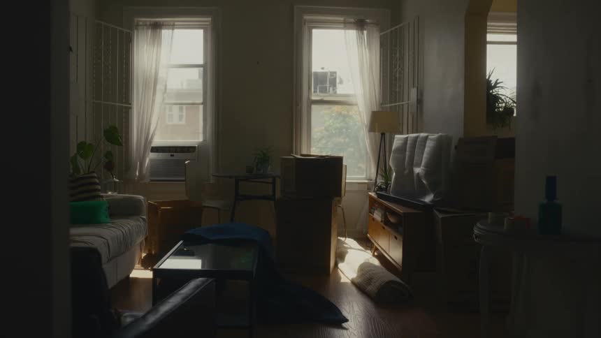 Couple holding hands in a room of the house with light coming through the window