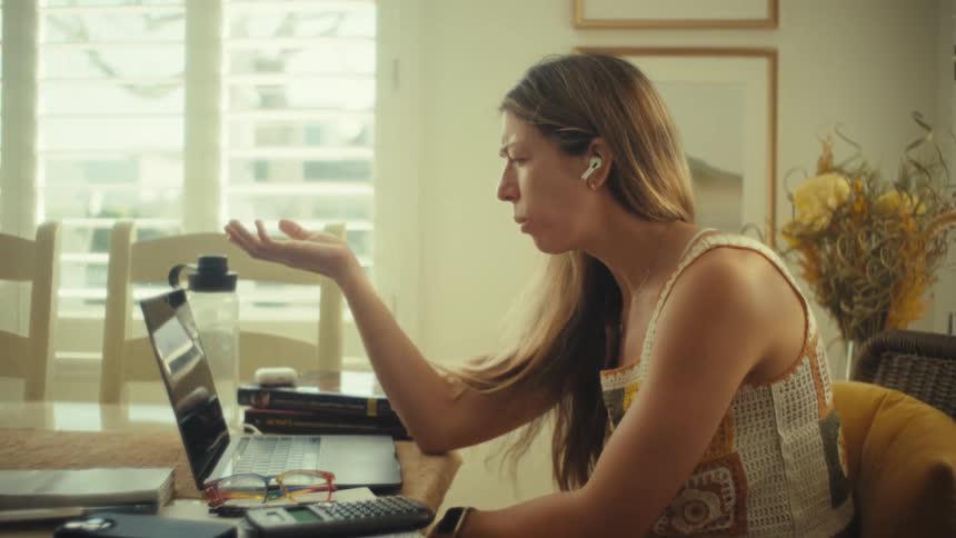 Teenage girl sitting at a desk having a conversation on a laptop computer