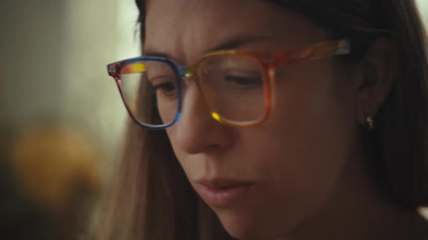 Woman wears colorful glasses while looking at something ahead