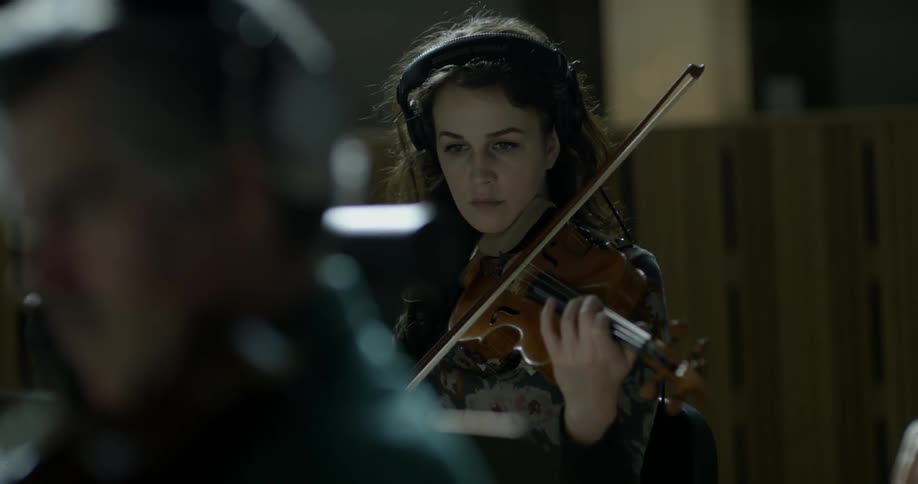 People are playing violins in an orchestra