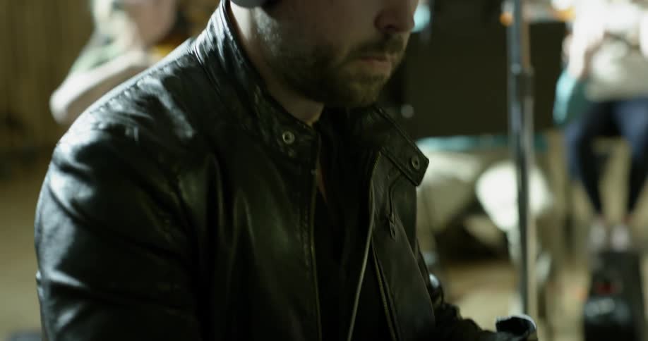 A man plays a piano while wearing headphones