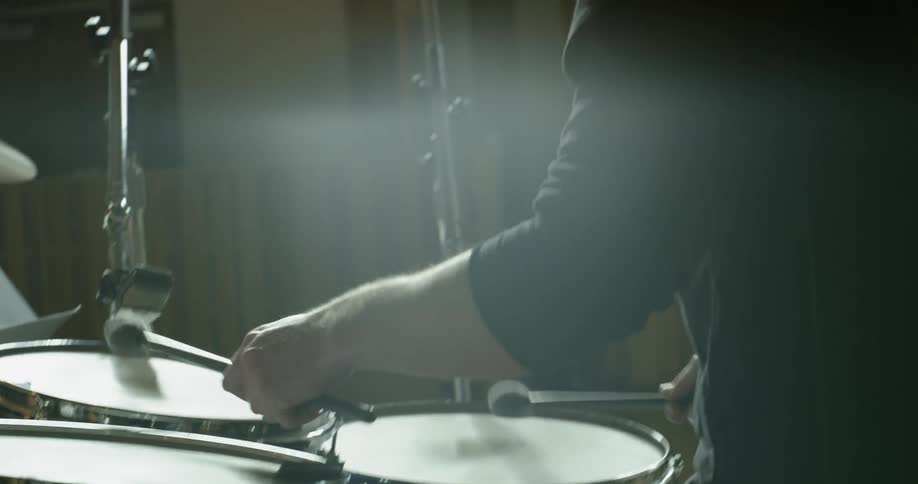A drummer is performing in a music studio