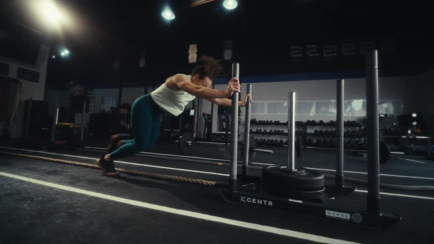 Woman pushes a training sled in a gym during a strength workout