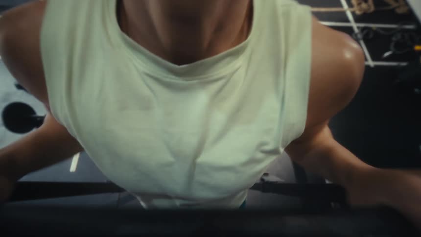 Woman performs a pullup in a gym during a workout