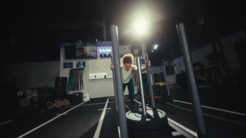 A woman pushing weights in a gym