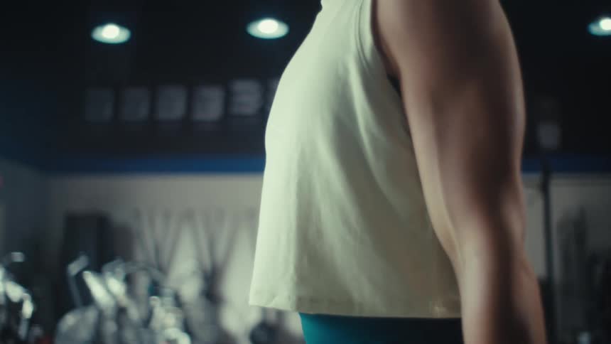 A woman curling weights in a gym