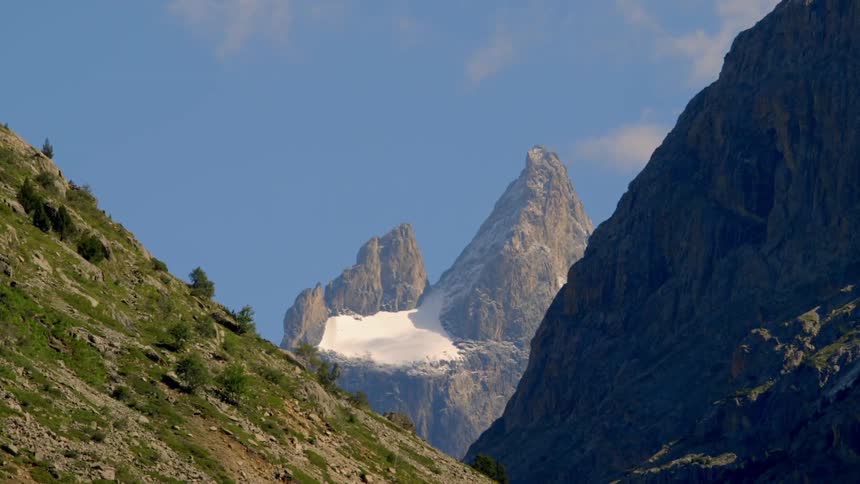 Partially snow and tree covered mountains on a sunny day