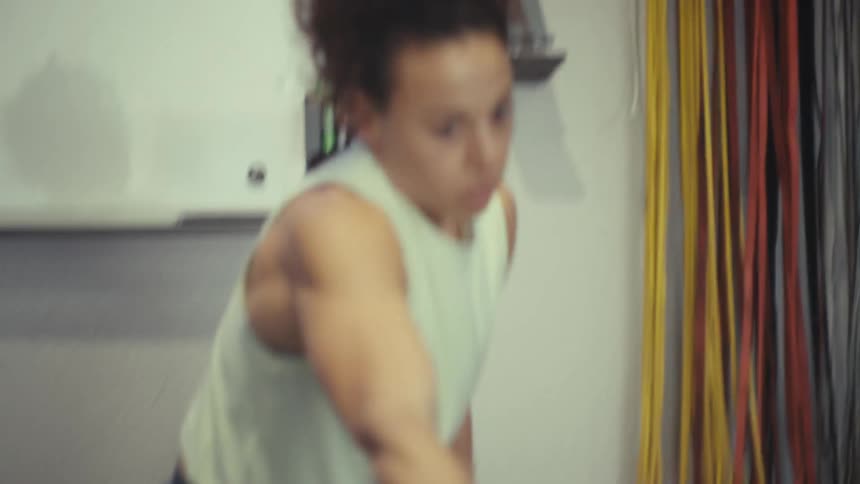 Woman performs physical exercise with arm movement indoors