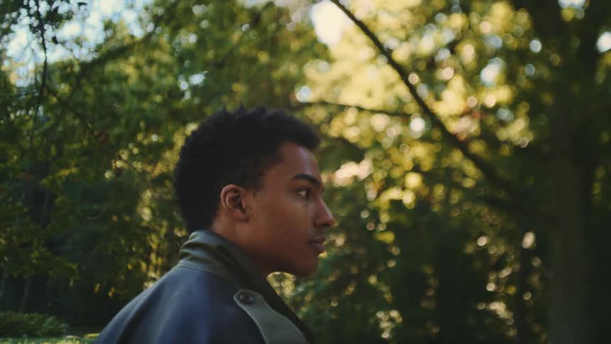 Young man walking outside of the woods looking around